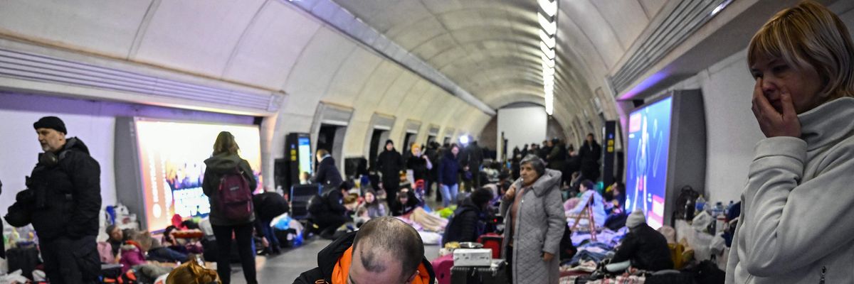 A man hugs his child in a makeshift bomb shelter in a metro station in Ukraine