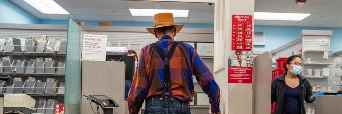 A man in a hat waits for his prescription to be filled