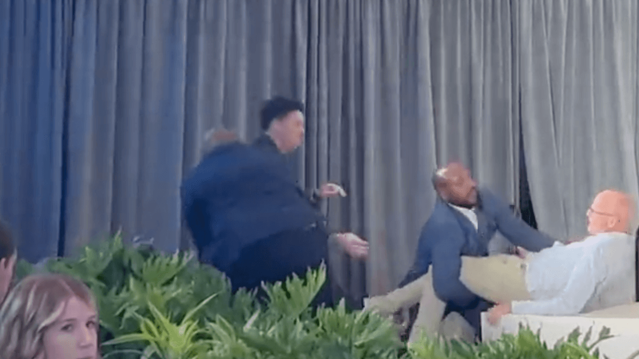 A man is dragged off a stage.