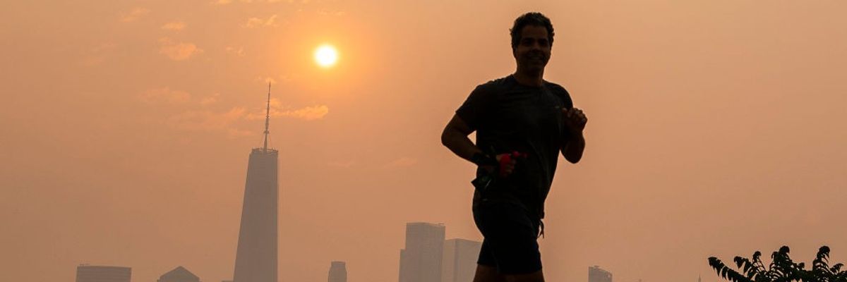 A man jogs in wildfire smoke with NYC in the background.