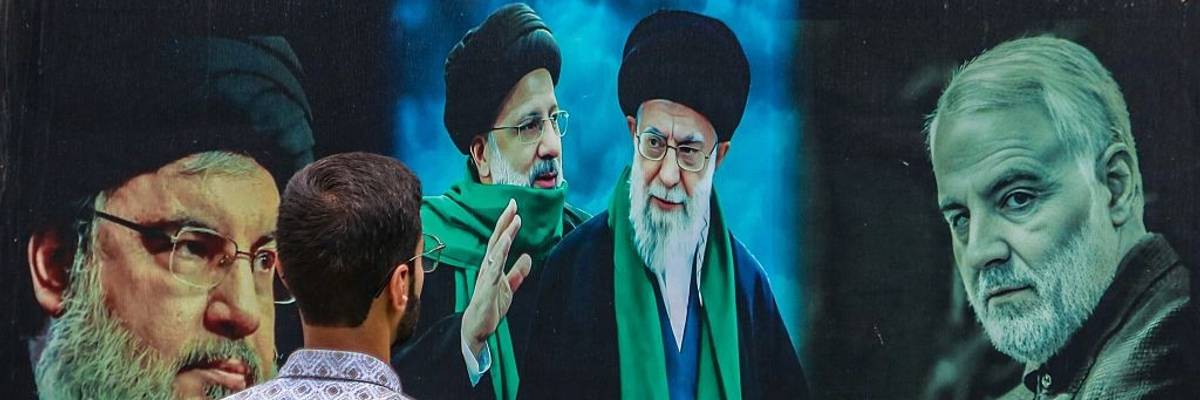 A man looks at a billboard featuring Iranian and Hezbollah leaders.