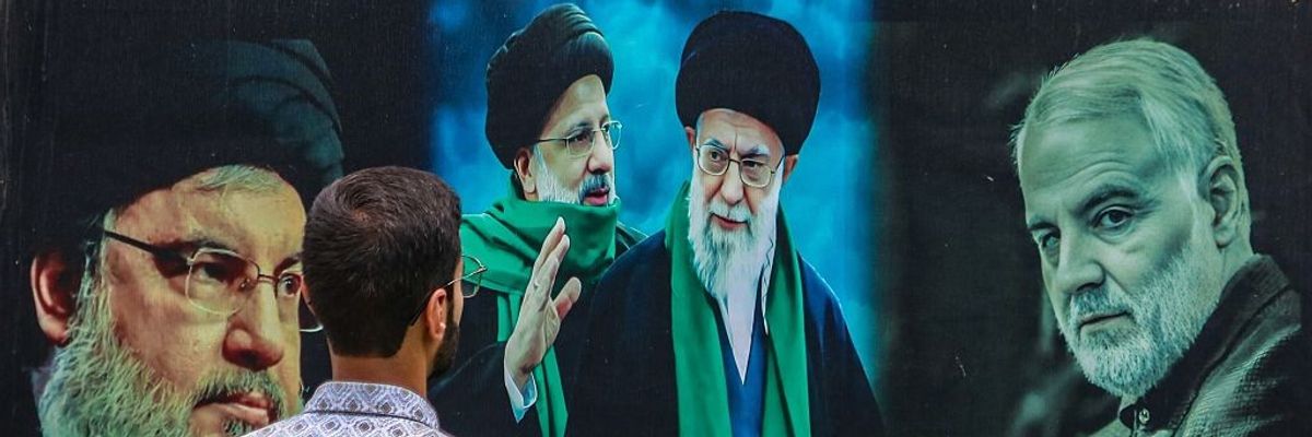 A man looks at a billboard featuring Iranian and Hezbollah leaders.