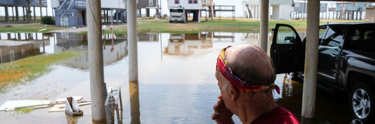 A man looks out across his flooded property the day after Hurricane Beryl