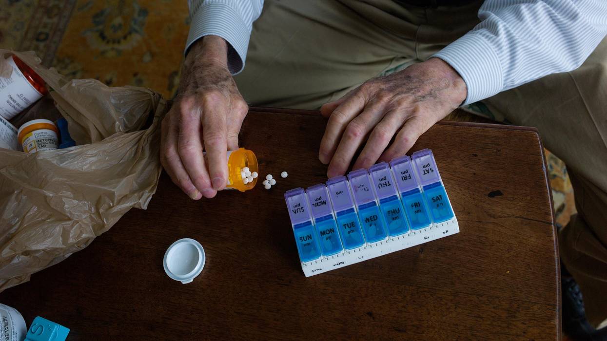 A man prepares the daily pills his wife will need