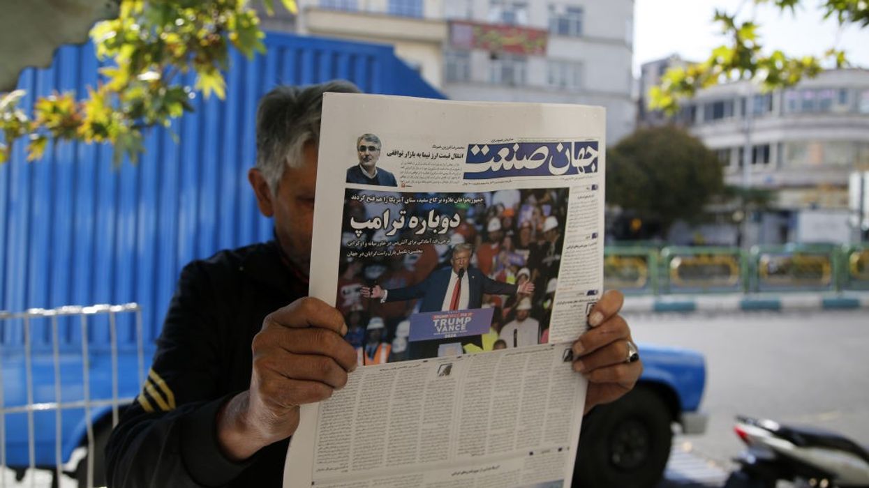 A man reads a newspaper with a story about the U.S. presidential election