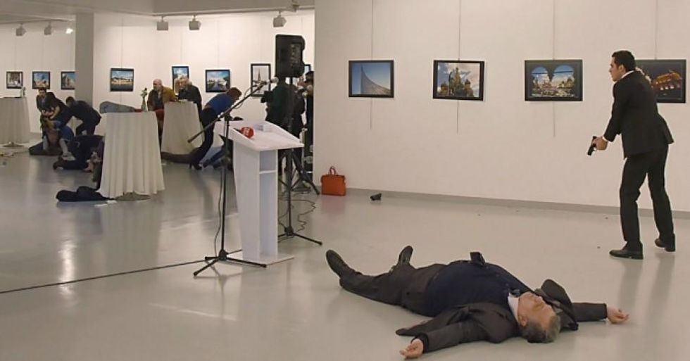 A man, right, reported by The Associated Press to be the gunman, after the shooting of the Russian ambassador Andrei Karlov, on the floor, on Monday at a gallery in Ankara, the capital of Turkey. (Credit: Yavuz Alatan/Agence France-Presse -- Getty Images)