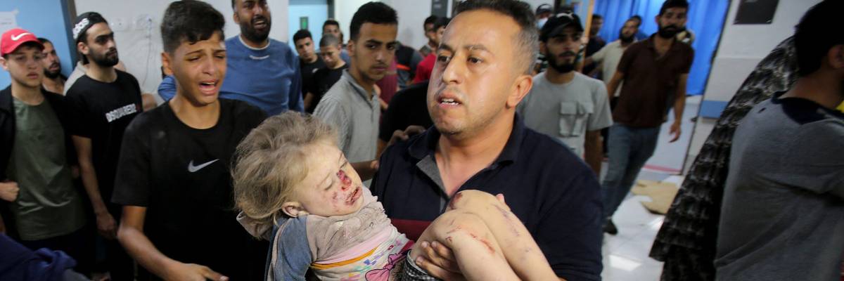 A man rushes a child into the al-Shifa Hospital