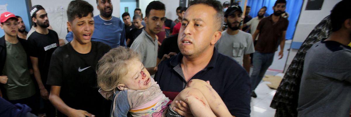 A man rushes a child into the al-Shifa Hospital