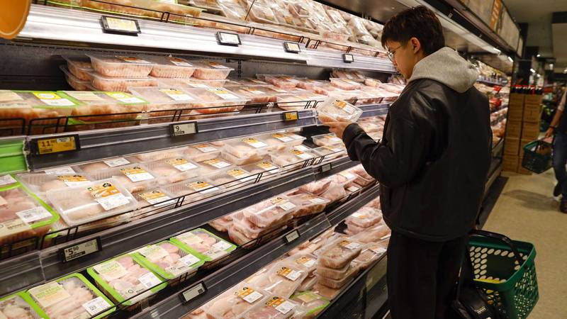 A man seen checking the meat price at a Woolworths supermarket in Melbourne, Australia