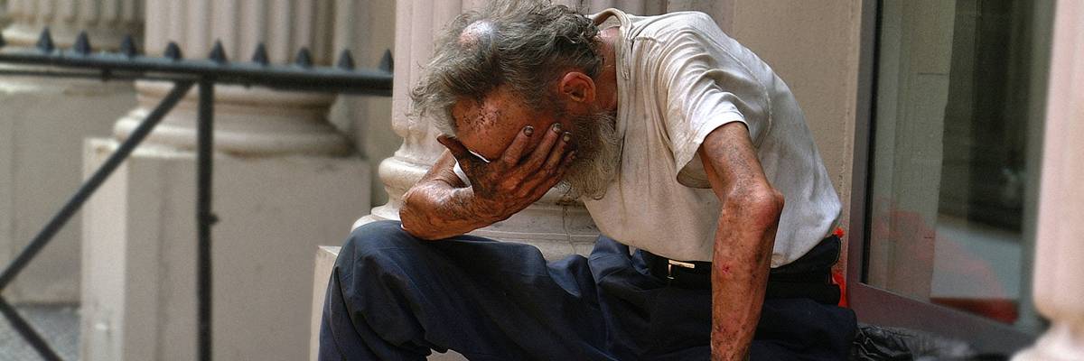 A man sitting on a step with his head in his hands