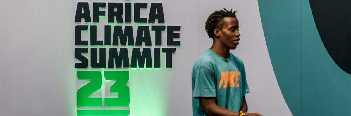 A man stands in front of the Africa Climate Summit 23 logo.
