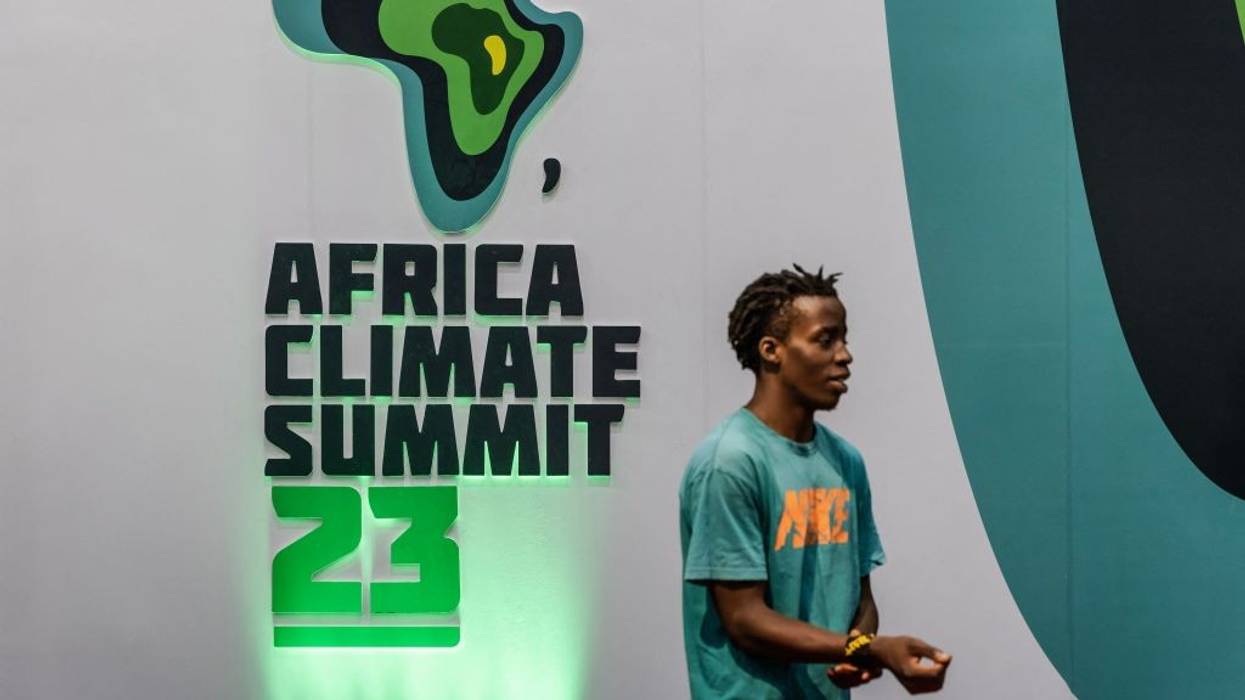 A man stands in front of the Africa Climate Summit 23 logo.