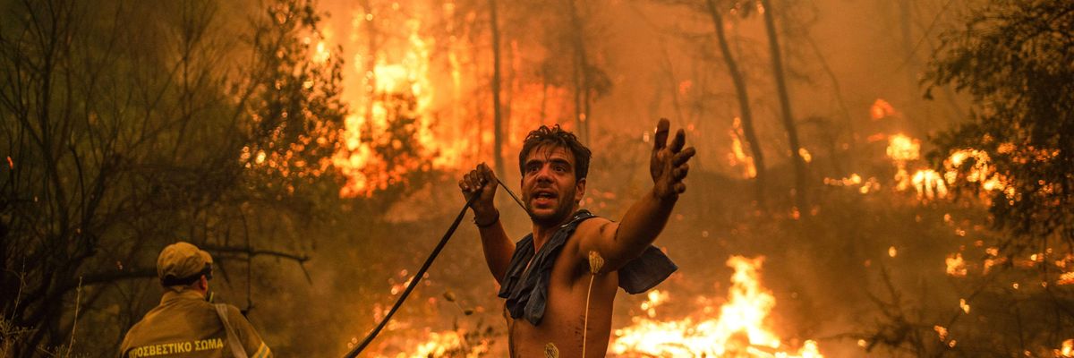 A man trying to put out a wildfire in Greece