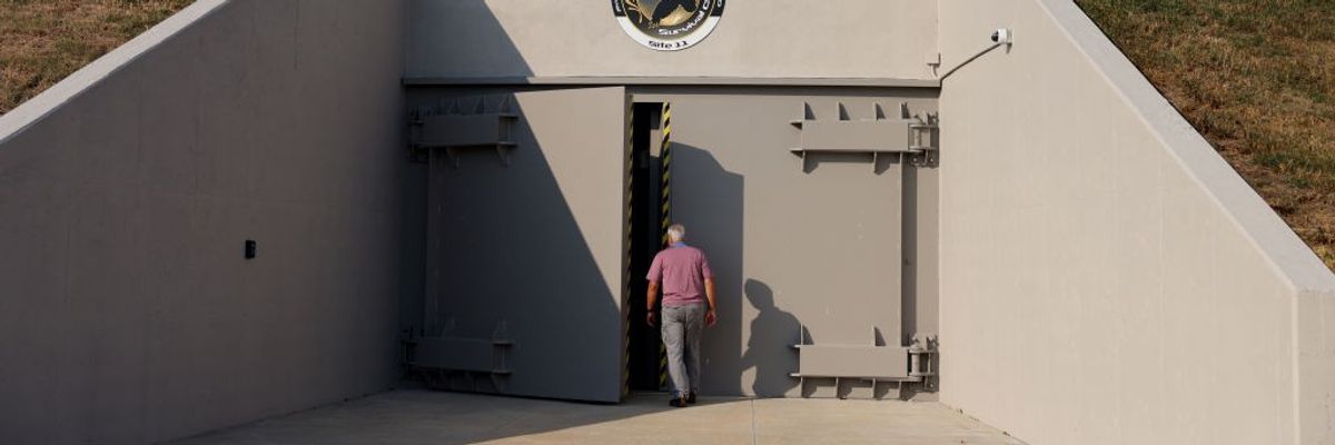 A man walks into a bunker in a hillside.