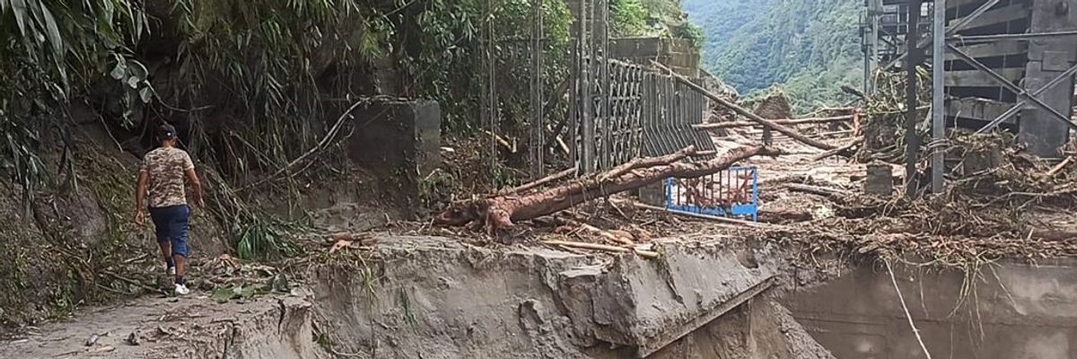 A man walks on a washed out road in India.