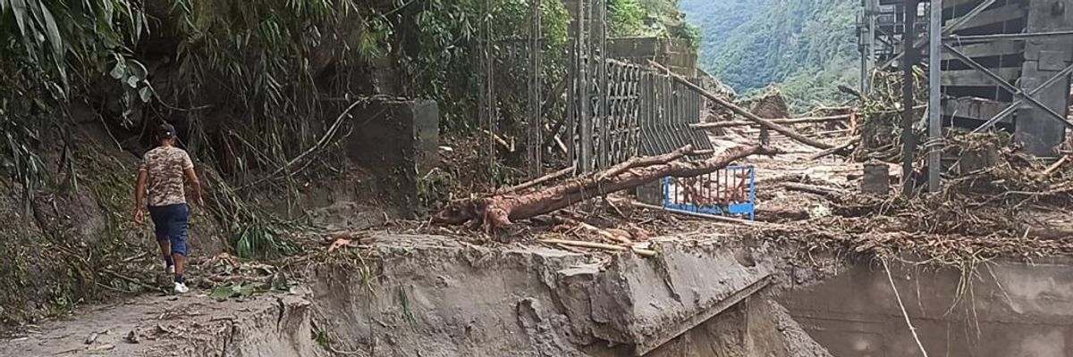 A man walks on a washed out road in India. 