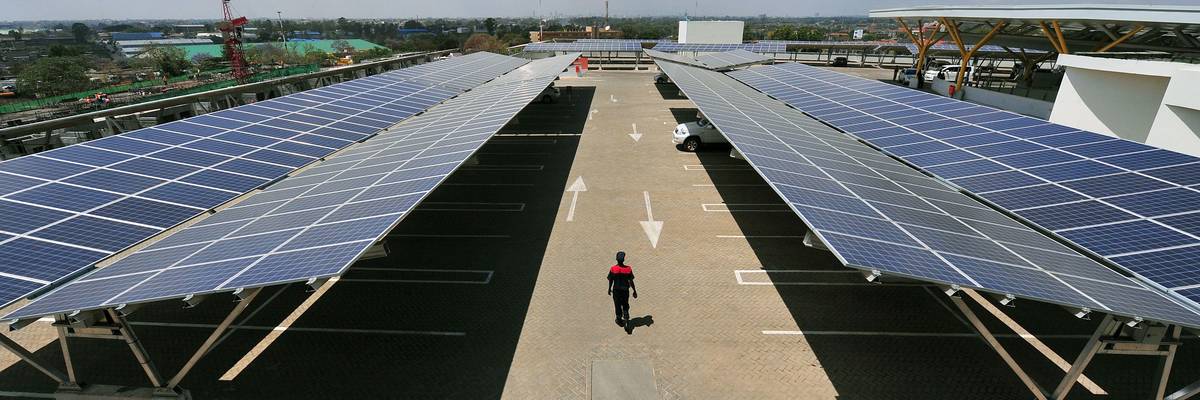 A man walks through a rooftop solar carport on October 26, 2015 in Nairobi.