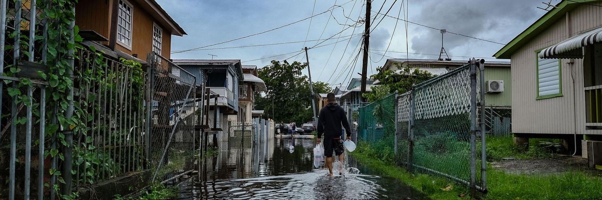 a man walks through floodwaters