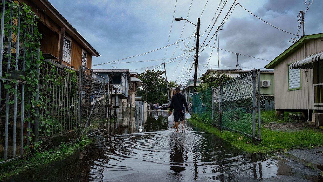 a man walks through floodwaters