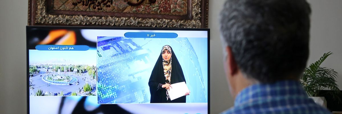 A man watches TV in Iran.