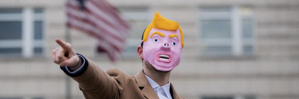A man wearing a mask meant to represent U.S. President Donald Trump with a pig's nose