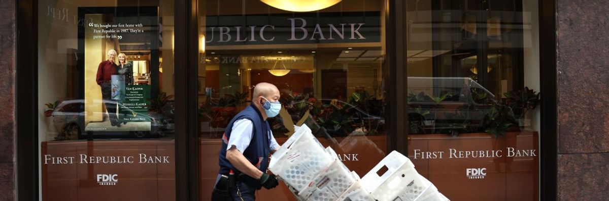 A man wheels boxes outside a First Republic Bank office.