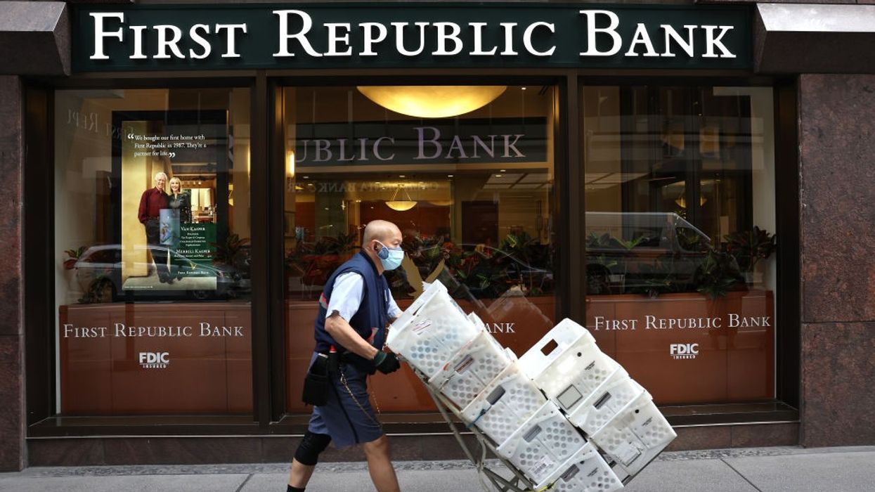 A man wheels boxes outside a First Republic Bank office.