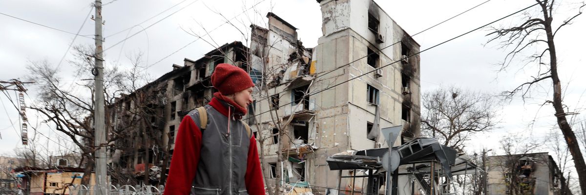 A Mariupol resident walks amid the city's ruins