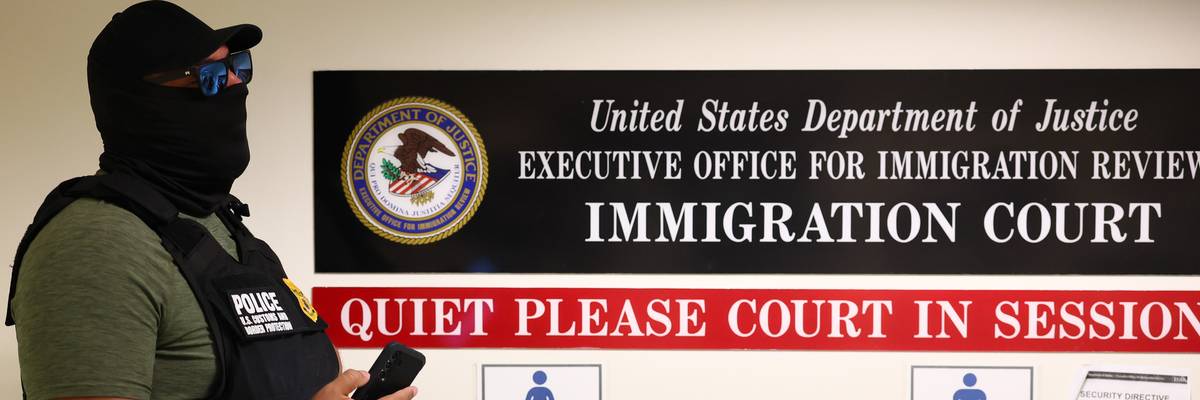 A masked federal agent in an immigration court.