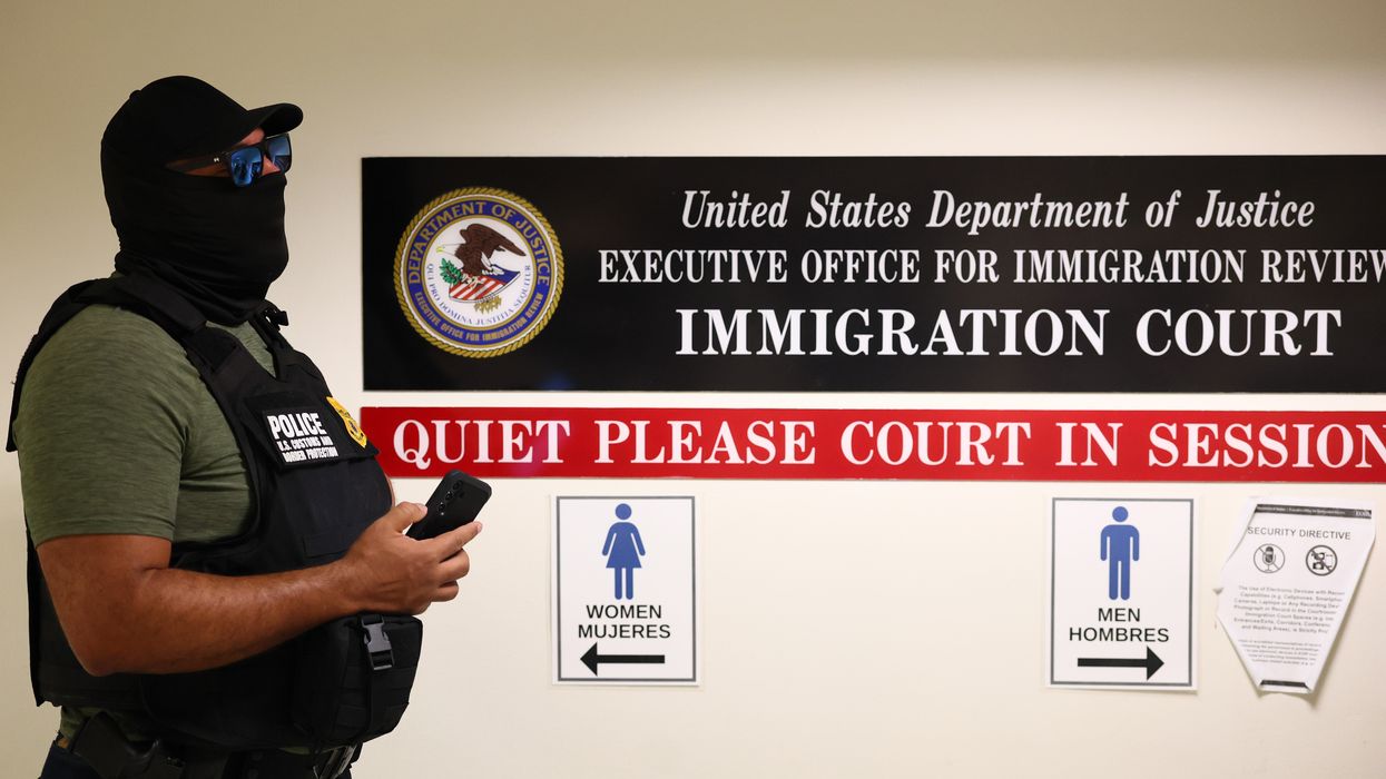 A masked federal agent in an immigration court.