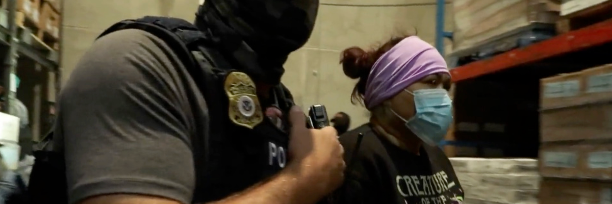 A masked ICE agent arrests a woman