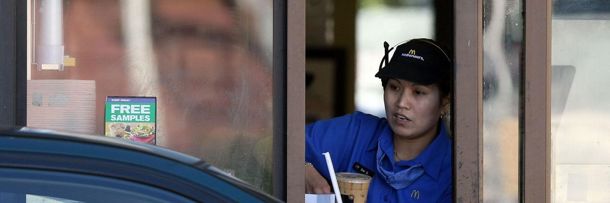 A McDonald's drive thru worker hands an order to a customer in San Francisco, California.