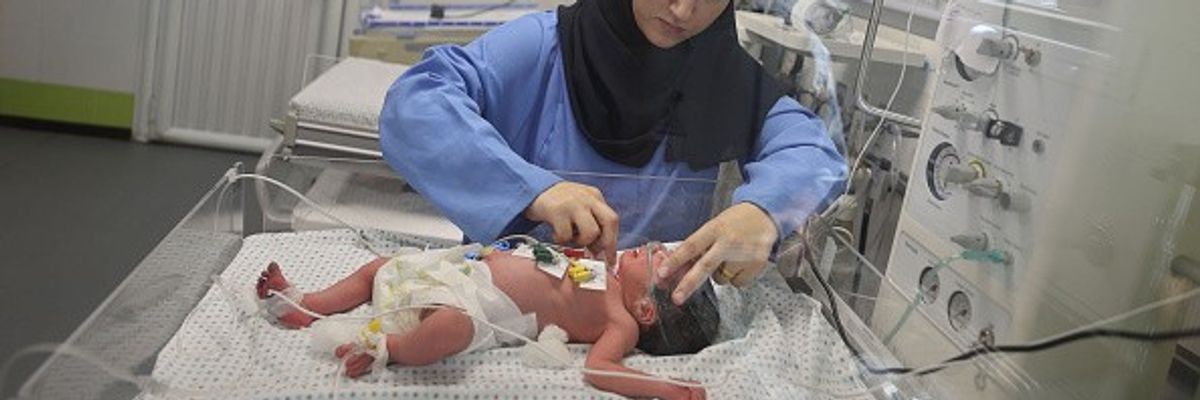 A medical personnel checks a newborn at Nasser Hospital
