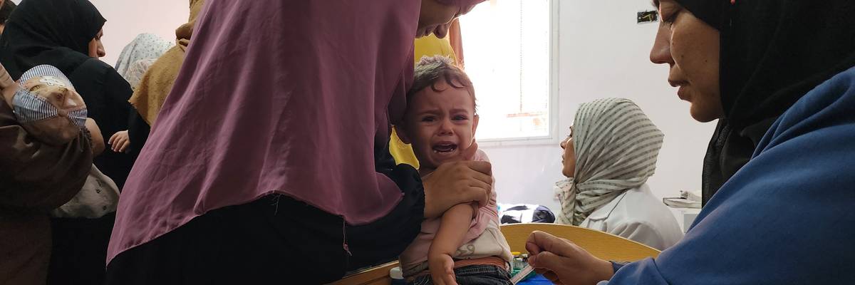 A medical team from the Palestinian Red Crescent administers a polio vaccine to a child