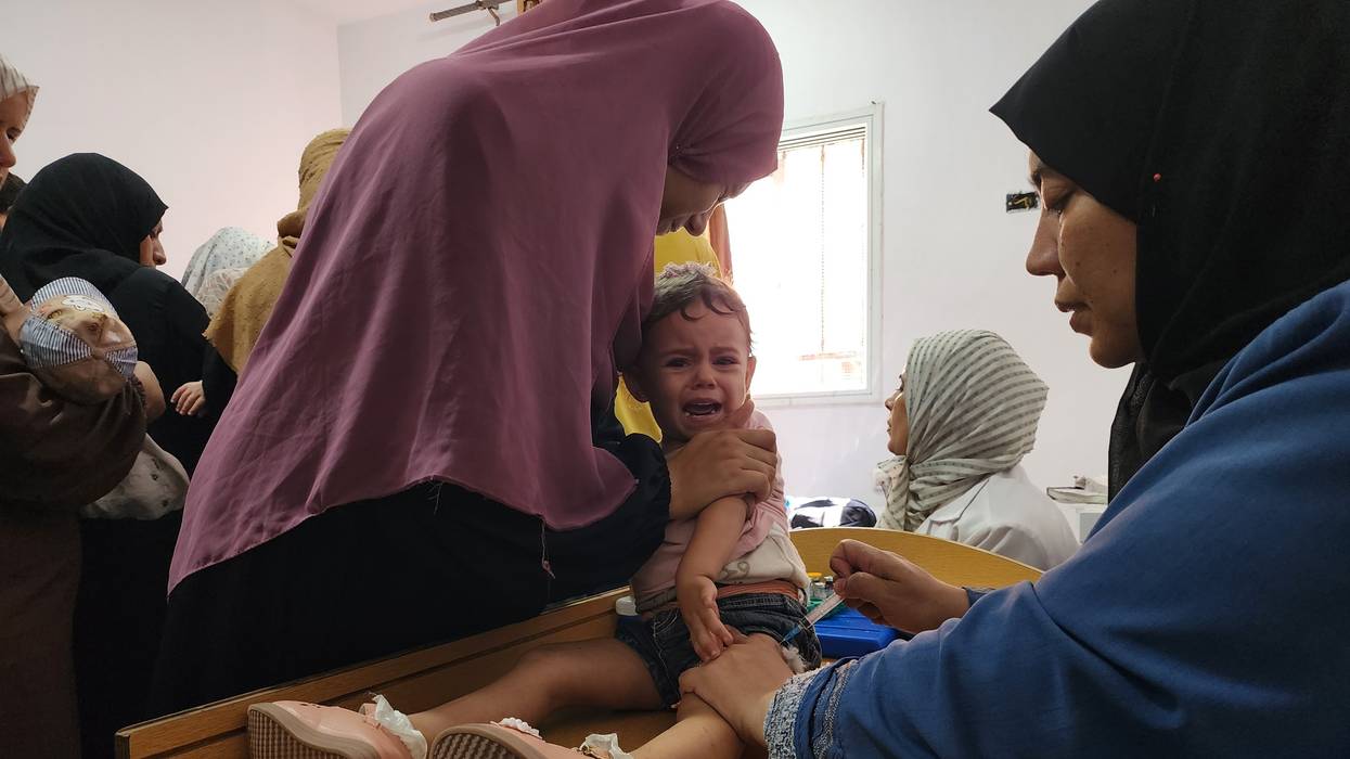 A medical team from the Palestinian Red Crescent administers a polio vaccine to a child