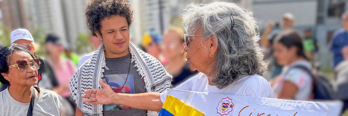 A member of Grandparents of the Homeland greets a solidarity brigade to Ciudad Tiuna, Venezuela.