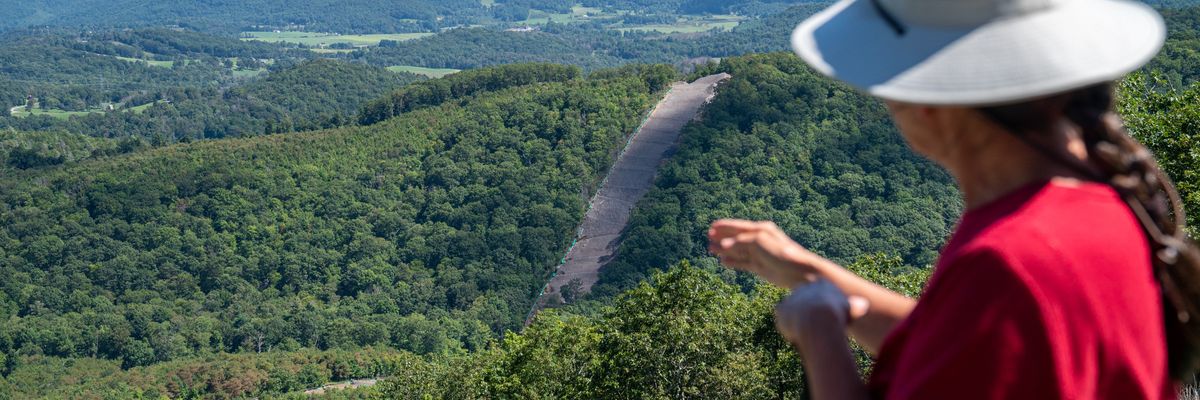 A member of Protect Our Water, Heritage, Rights (POWHR) views where sections of steel pipe of the Mountain Valley Pipeline have been buried