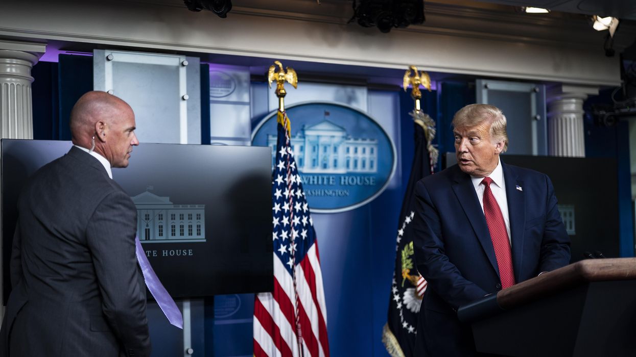 A member of the Secret Service speaks to then-President Donald Trump at the White House on August 10, 2020 in Washington, D.C.