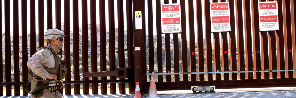 A member of the U.S. military walks along the border wall at the U.S. and Mexico border