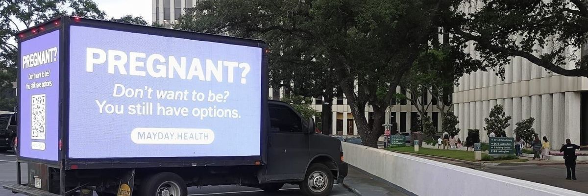 A mobile billboard reads, "Pregnant? Don't want to be? You still have options."