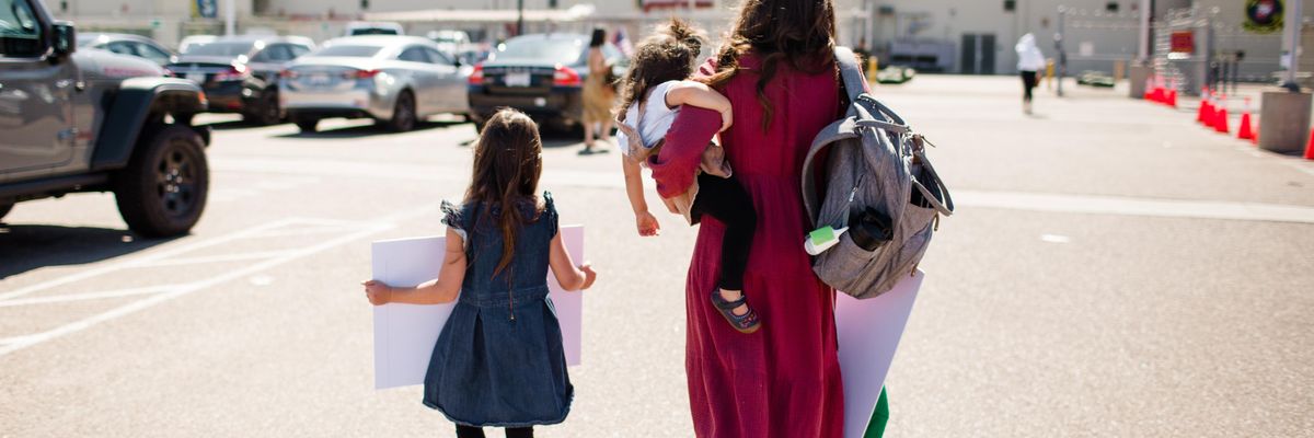 A mother and her two daughters walking onto a military base
