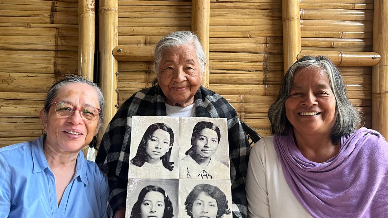 A mother and two daughters show a picture of their disappeared daughter and sister.
