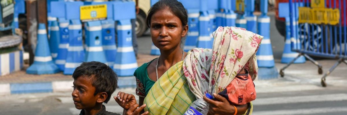 A mother covers her baby with a saree amid a heatwave in Kolkata, India on April 18, 2023.