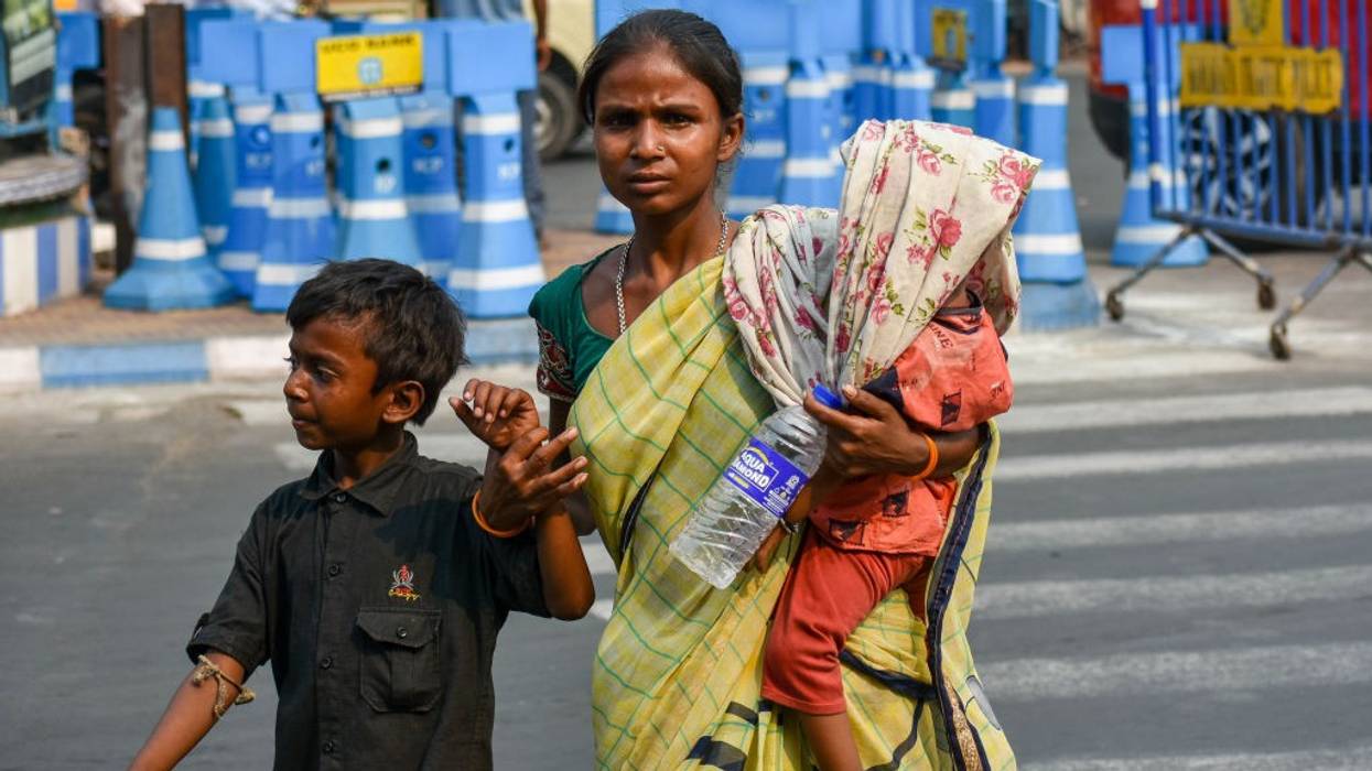 A mother covers her baby with a saree amid a heatwave in Kolkata, India on April 18, 2023.