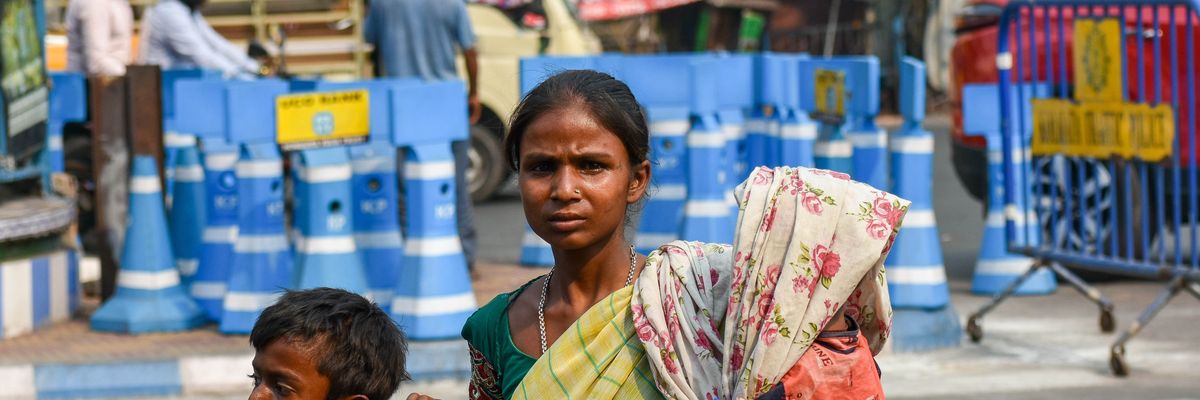 A mother covers her baby with a saree amid a heatwave in Kolkata, India on April 18, 2023.