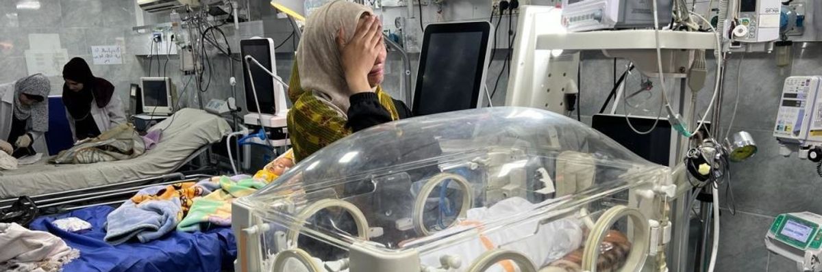 A mother cries over the body of her dead child in an incubator