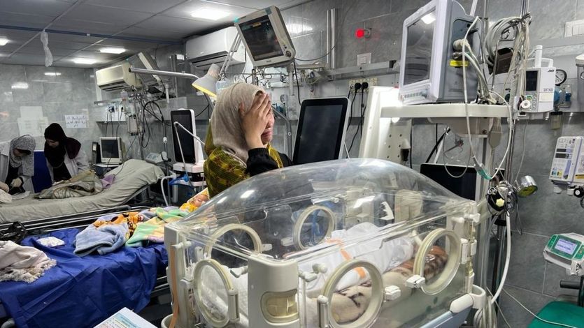 A mother cries over the body of her dead child in an incubator