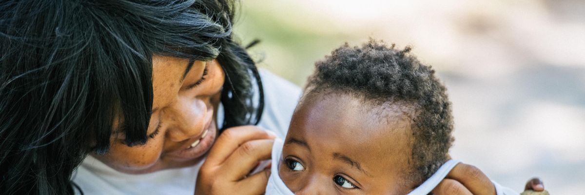 A mother puts a mask on her child