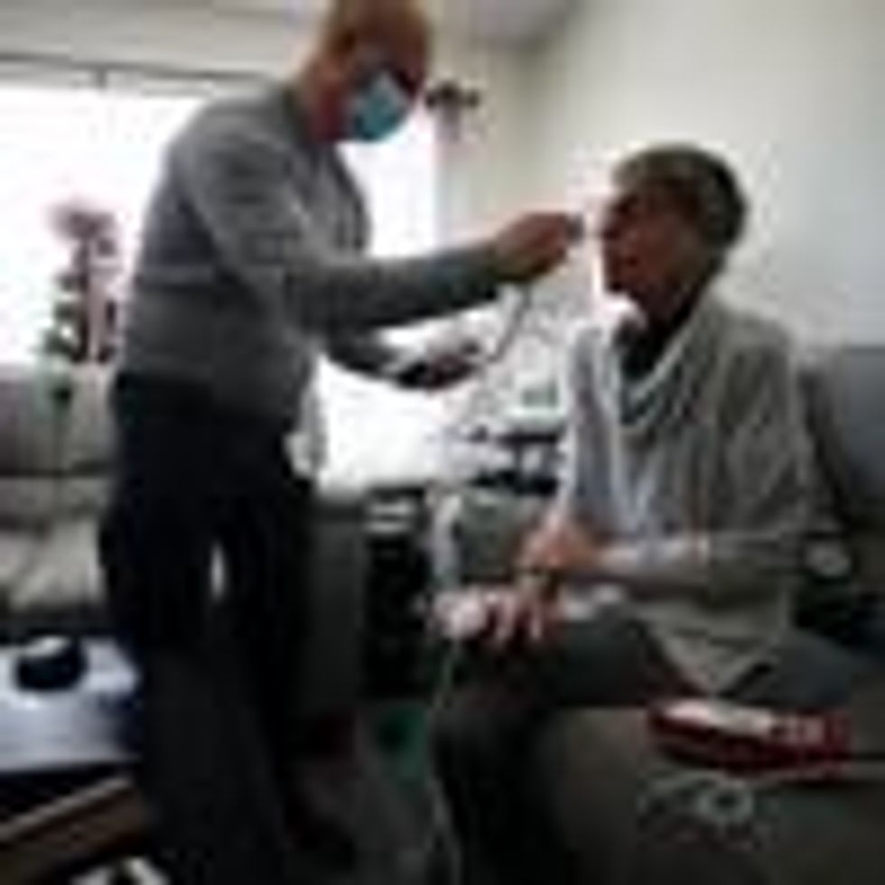 A nurse cares for a patient at home