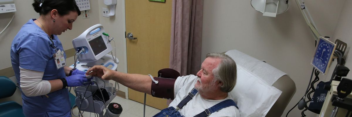 A nurse checks the blood pressure of a patient who gets health coverage through Medicare and Medicaid